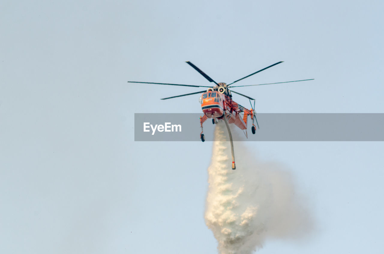 Firefighting helicopter dropping water