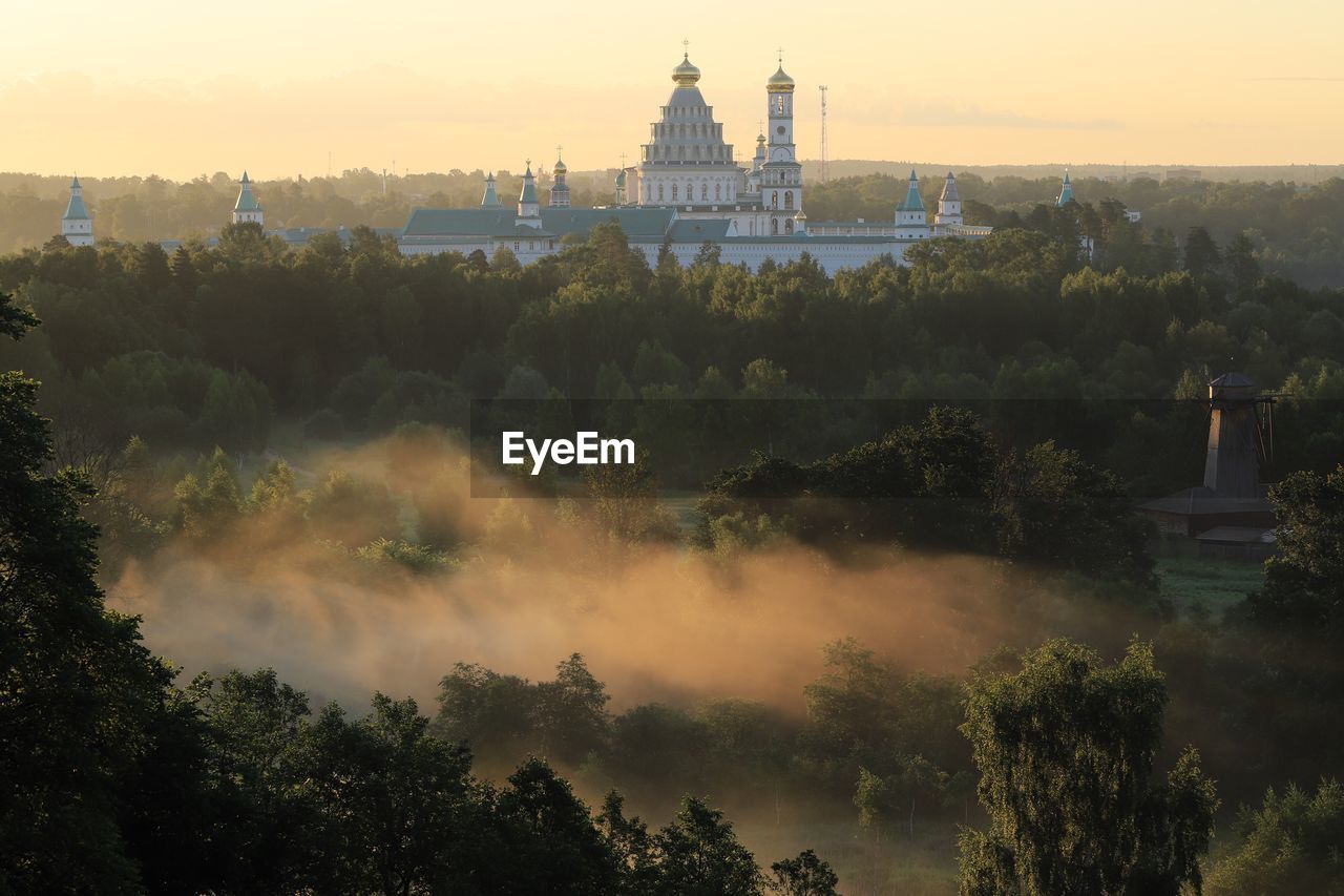 PANORAMIC VIEW OF TREES AND BUILDINGS AGAINST SKY