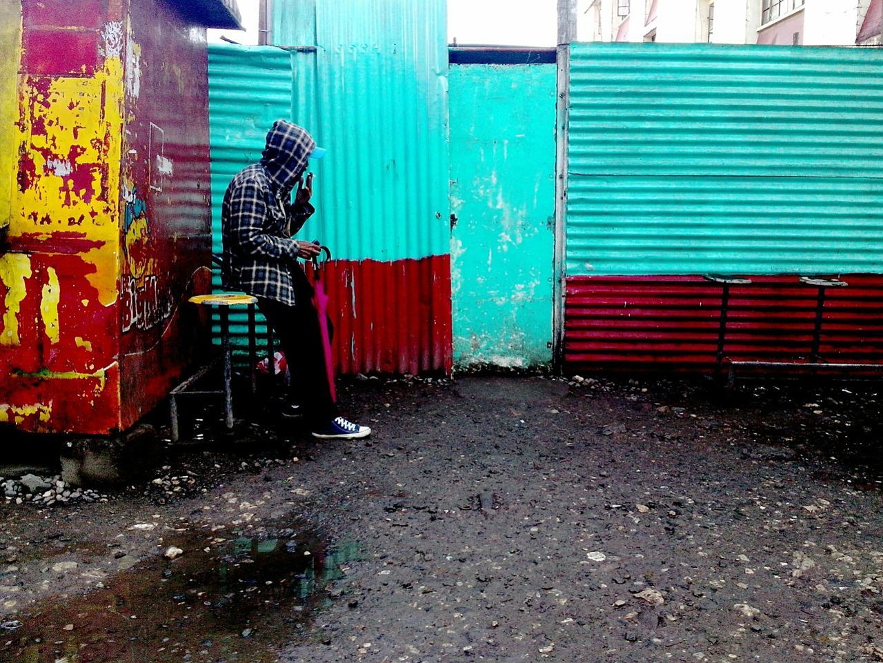 Side view of man in hooded shirt smoking outdoors