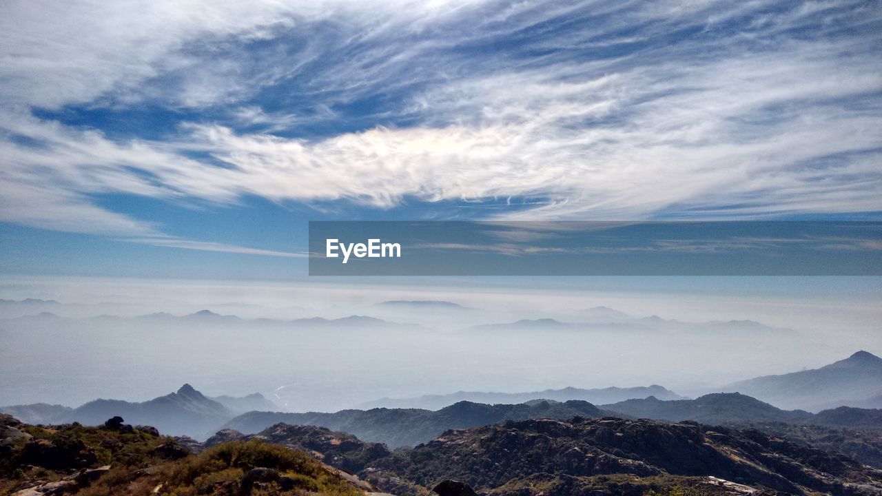 Scenic view of mountains against cloudy sky