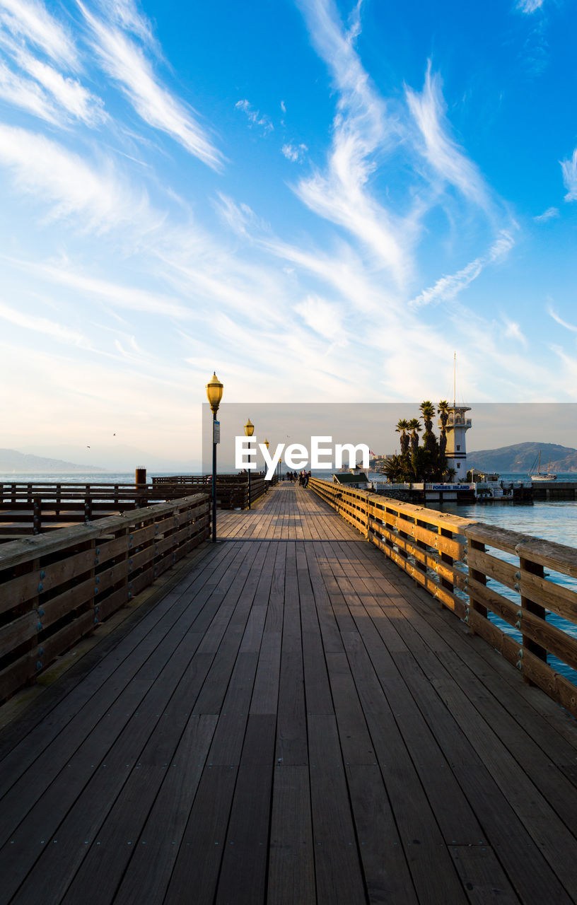 Empty pier over sea against sky