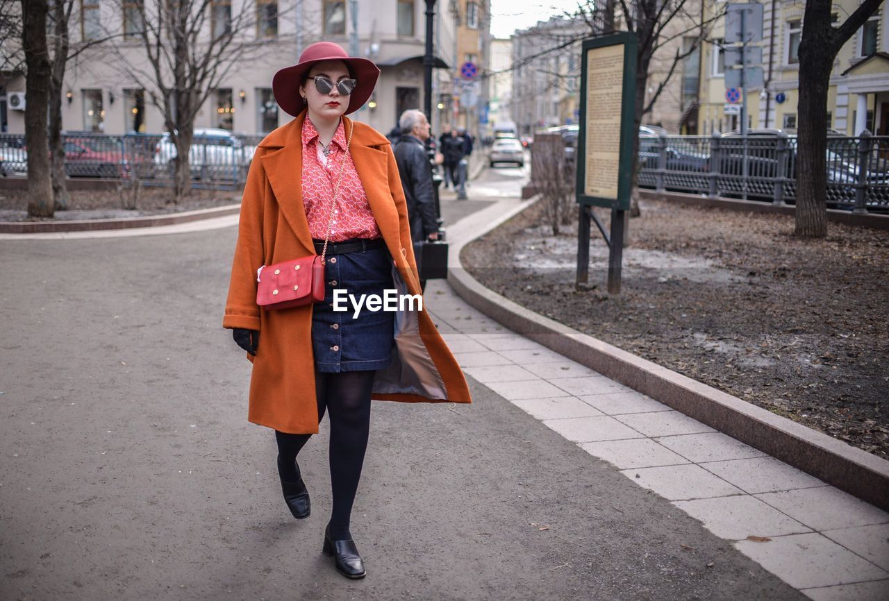 Full length portrait of woman in city during winter