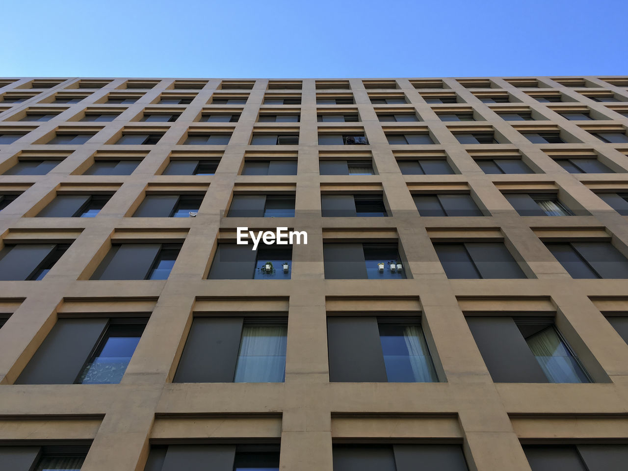 LOW ANGLE VIEW OF OFFICE BUILDING AGAINST CLEAR SKY