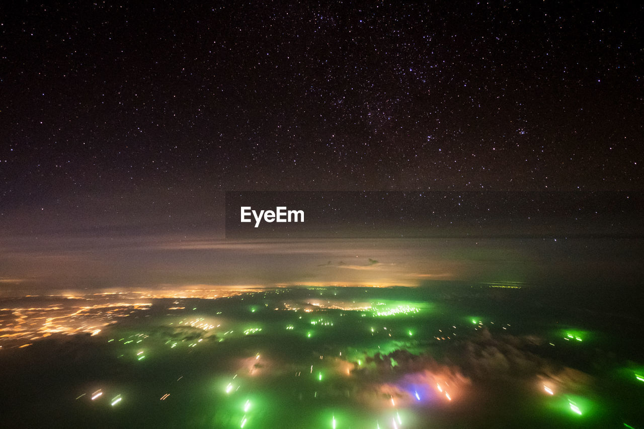 Aerial view of illuminated buildings against sky at night