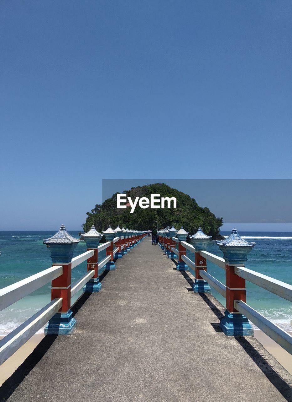 Scenic view of beach against clear blue sky