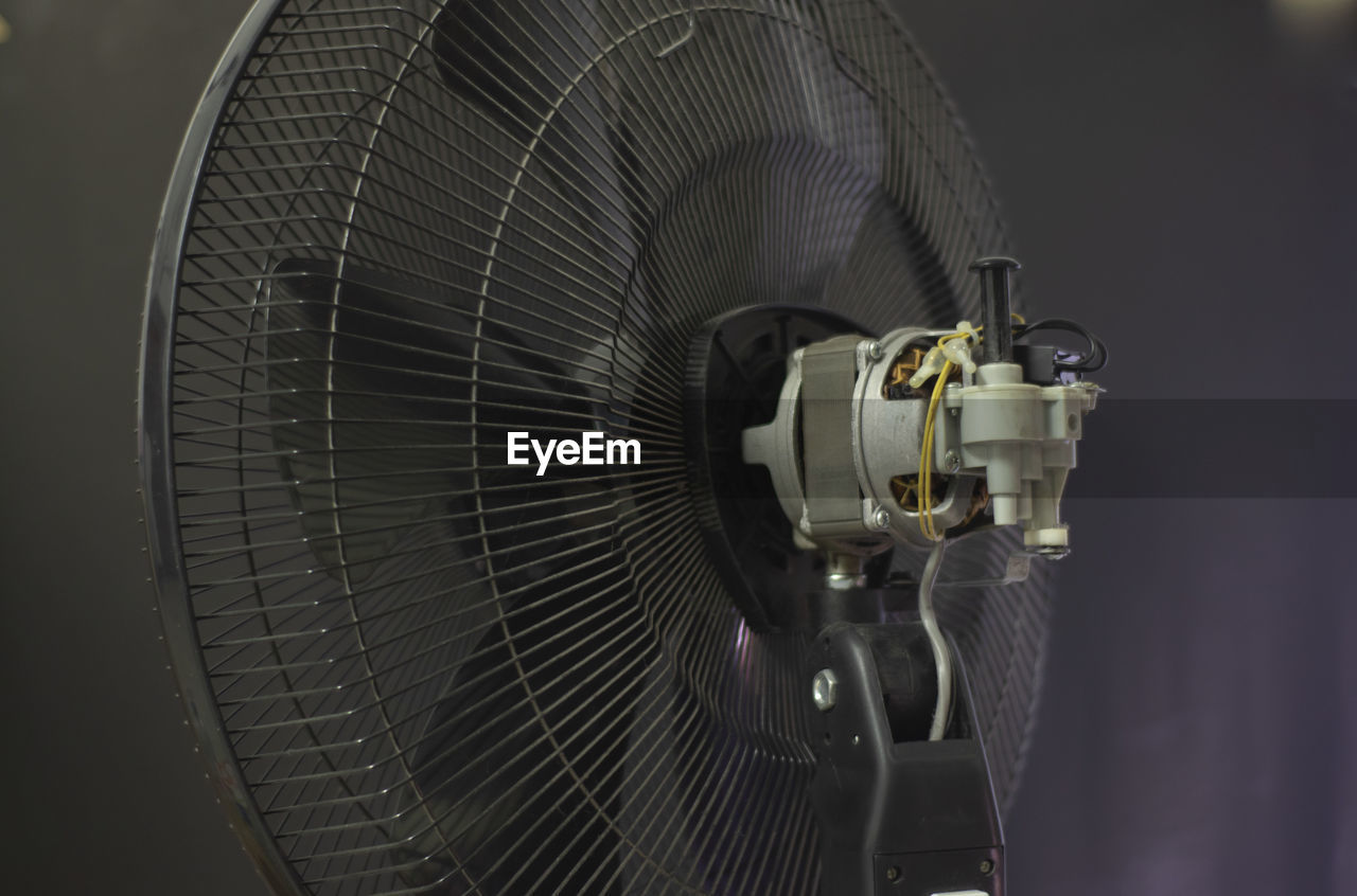 Close-up of electric fan against gray background