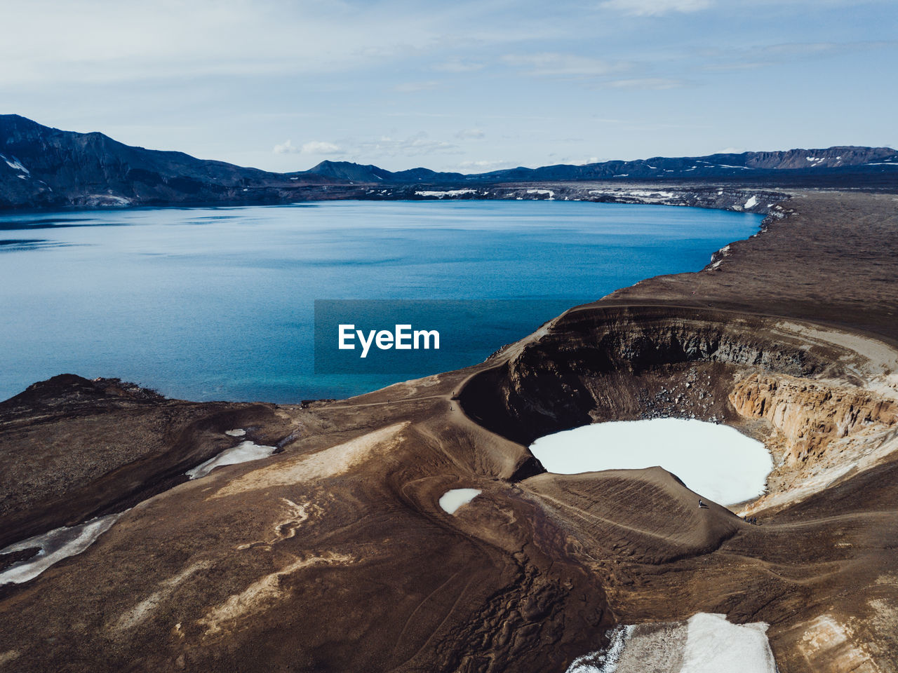 High angle view of volcanic crater by sea