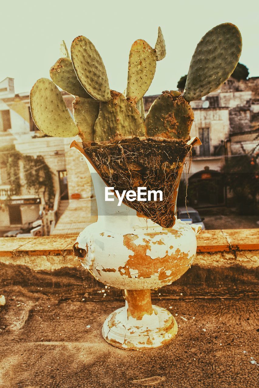 Close-up of old rusty vase against sky