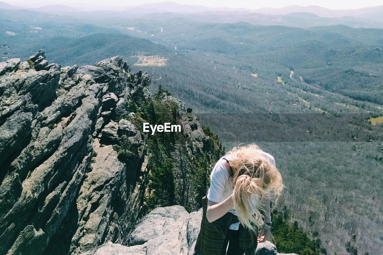High angle view of woman standing on mountain against landscape