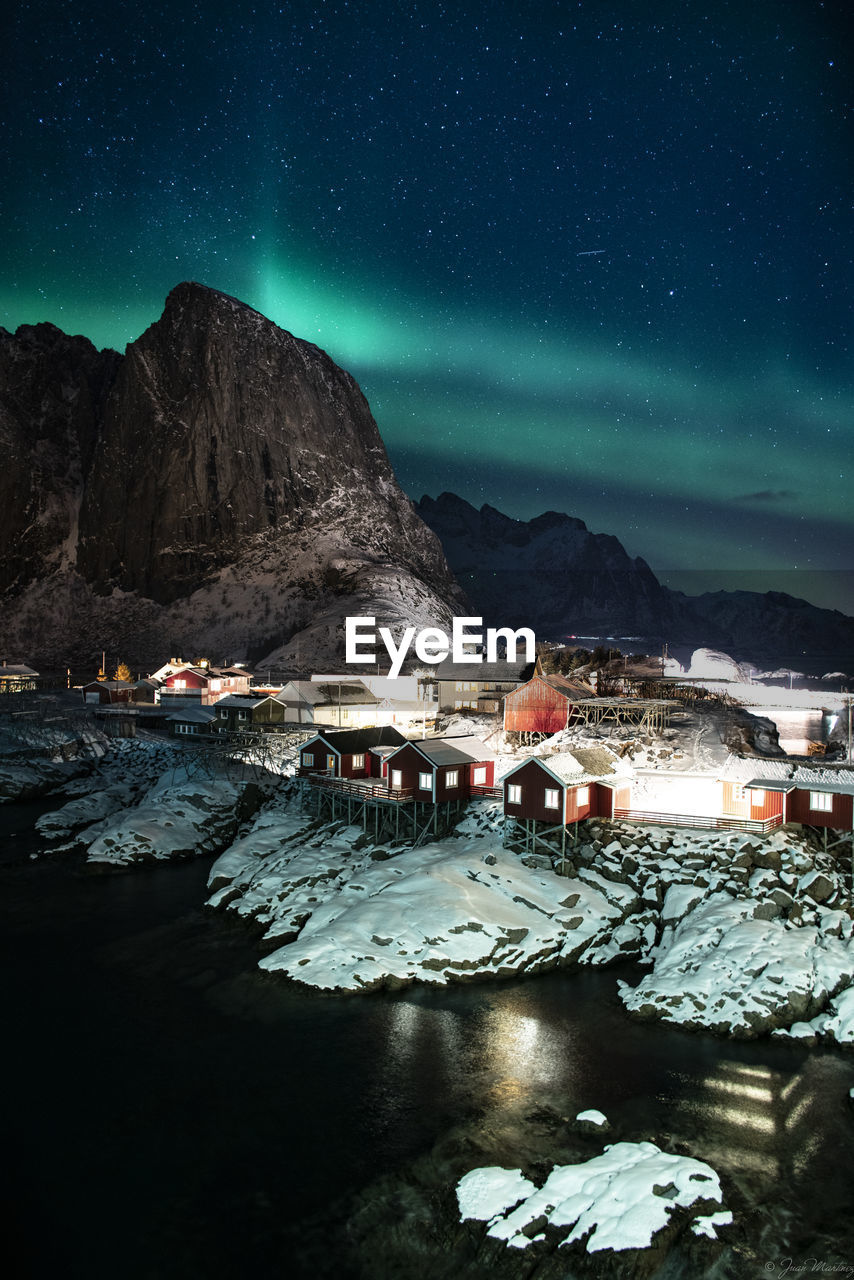 Northern lights over the fishing huts of lofoten islands, norway.
