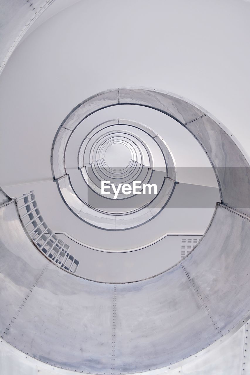 LOW ANGLE VIEW OF SPIRAL STAIRS AGAINST WHITE BACKGROUND