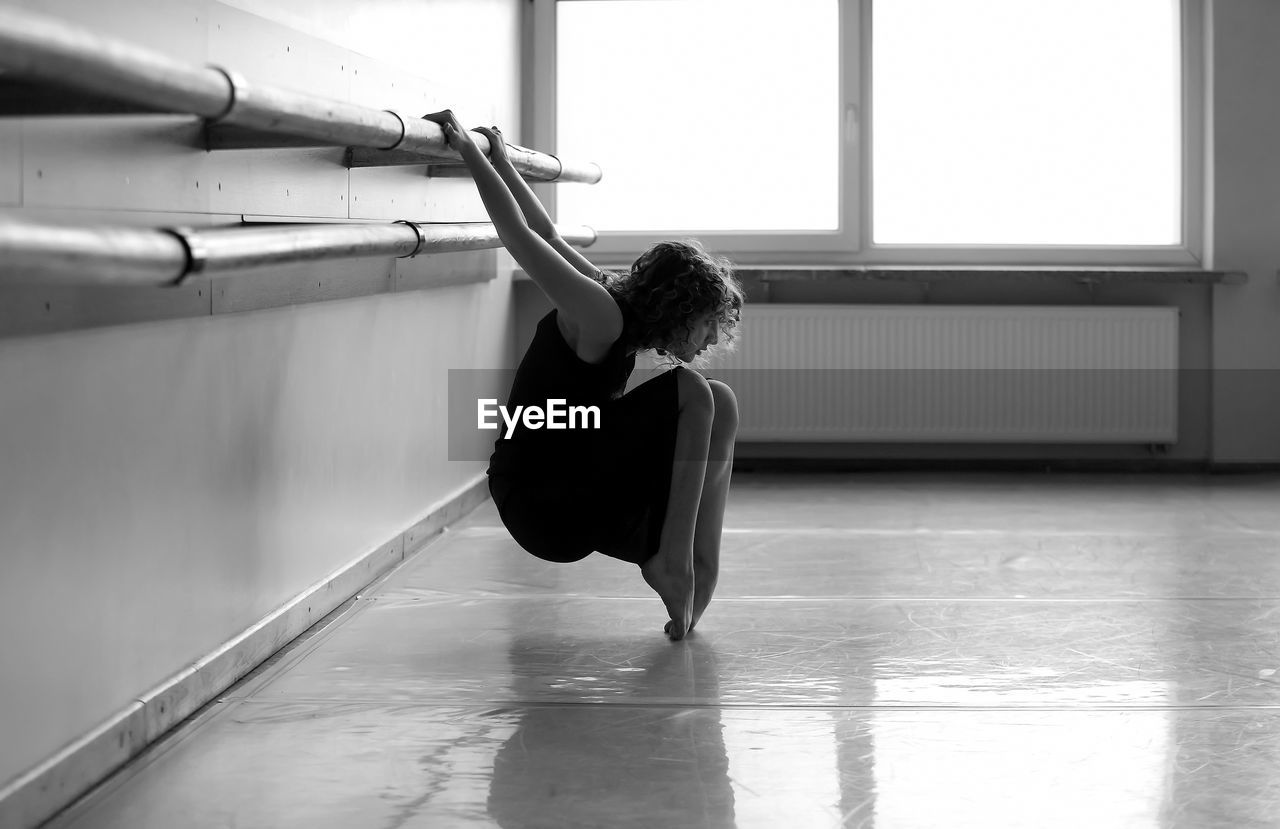 Teenage girl stretching at ballet studio