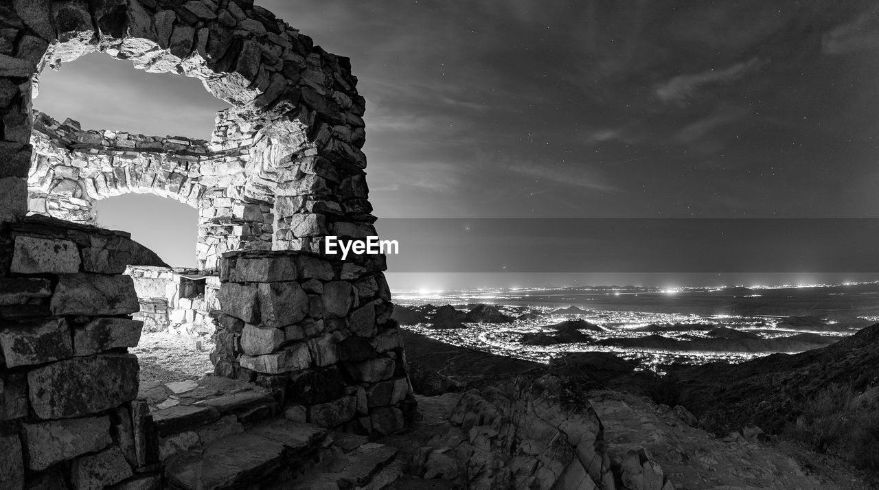 darkness, sky, architecture, black and white, monochrome, built structure, nature, monochrome photography, history, rock, cloud, night, travel destinations, the past, black, old ruin, no people, land, scenics - nature, white, ancient, wall, building, outdoors, building exterior, travel, water, landscape, environment, stone material, sea, beauty in nature, stone wall, light, tourism, old