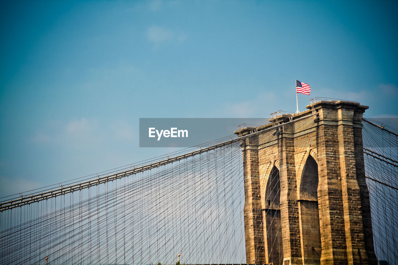 American flag on brooklyn bridge against sky