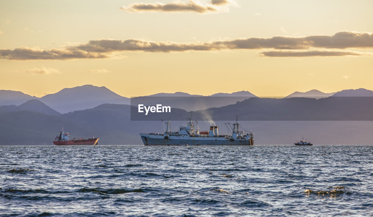 Large fishing vessel on the background of hills and volcanoes in kamchatka peninsula