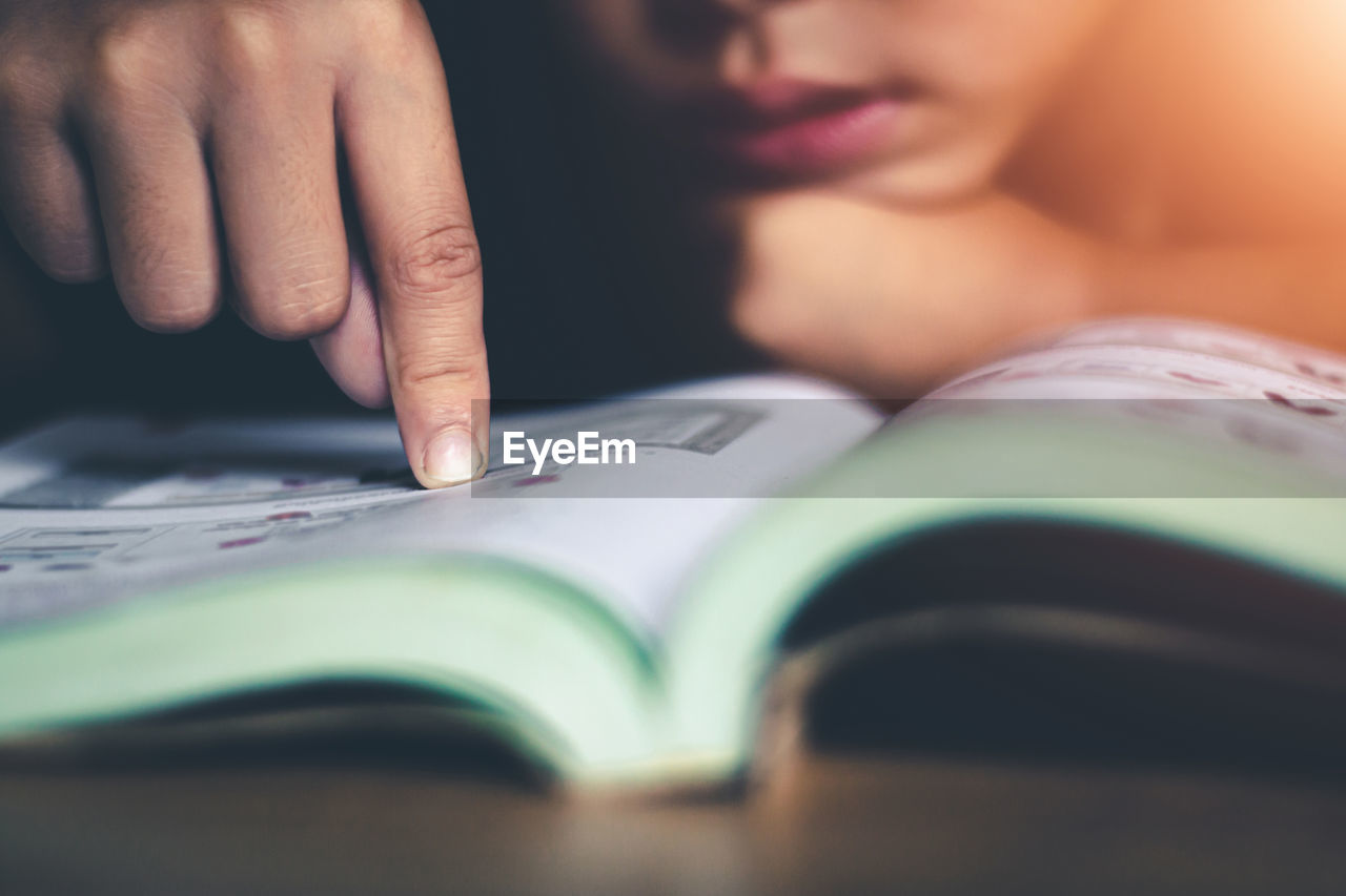 CLOSE-UP OF WOMAN HAND WITH BOOK