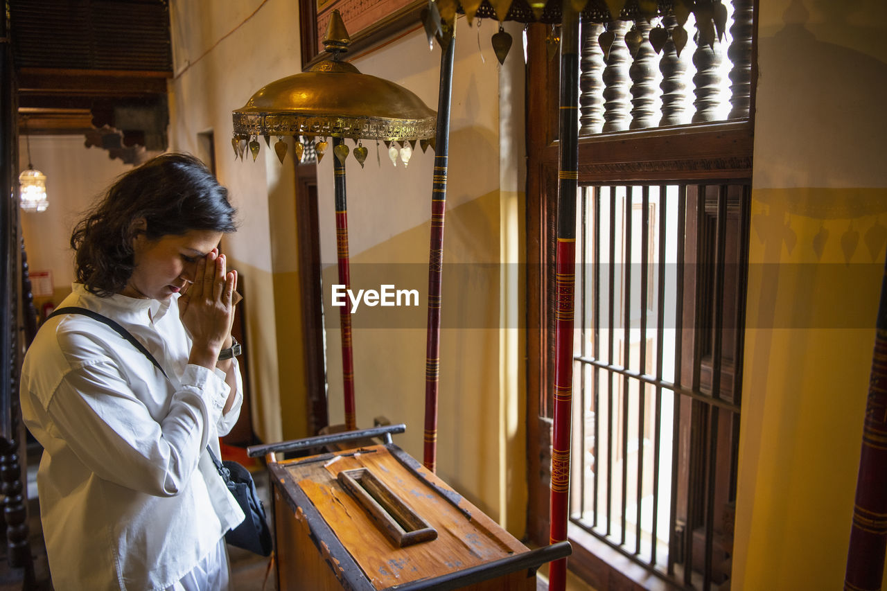 Buddhist worshiper donating at the temple of the holy tooth relic