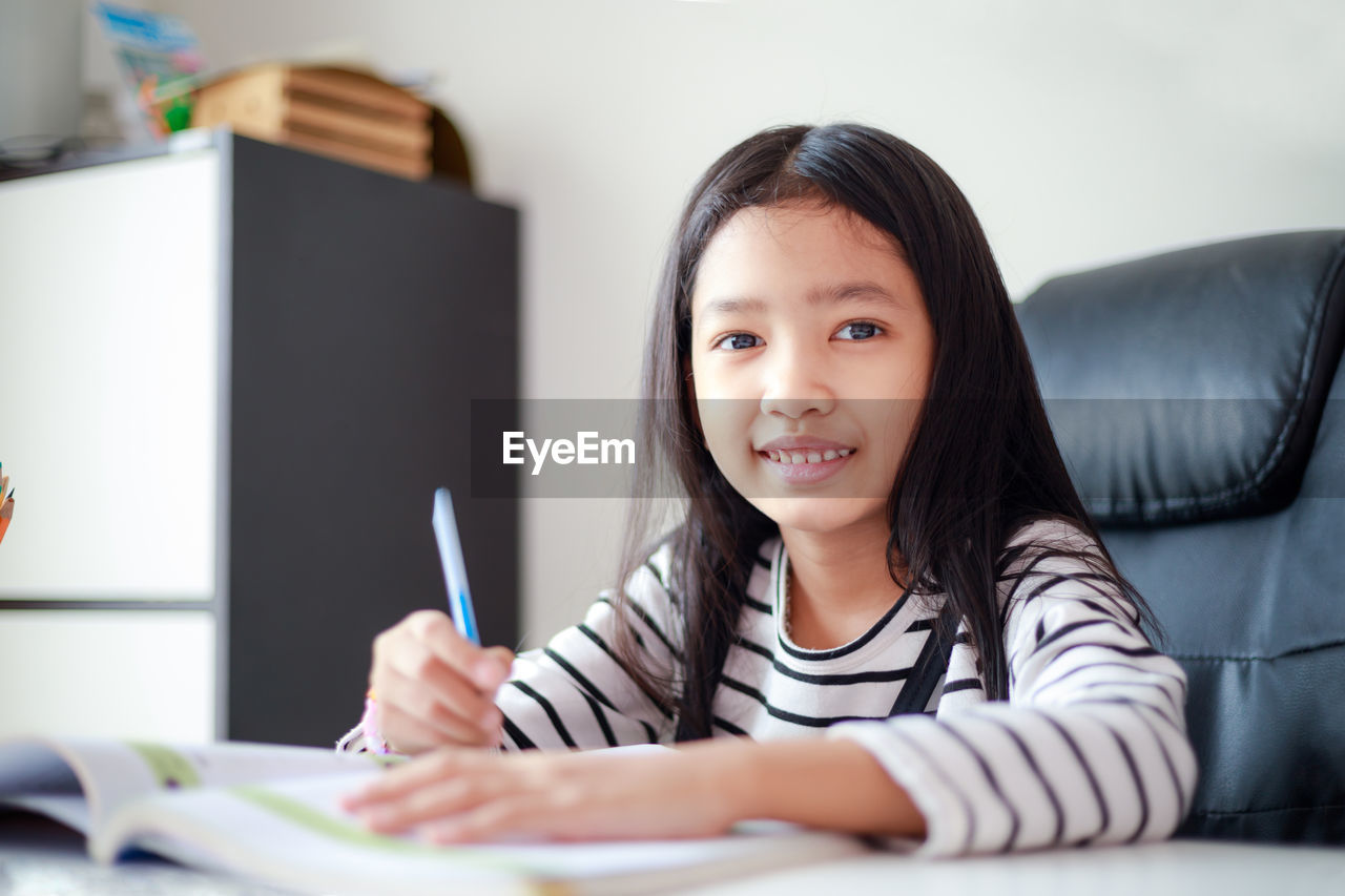 Portrait of smiling girl studying at home