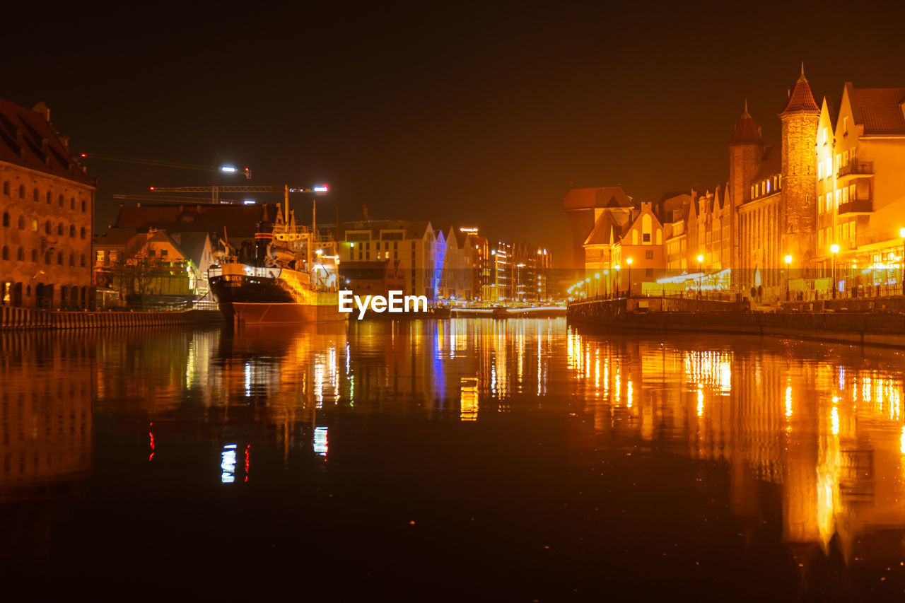 Old town in gdansk at night. the riverside on granary island reflection in moltawa river cityscape