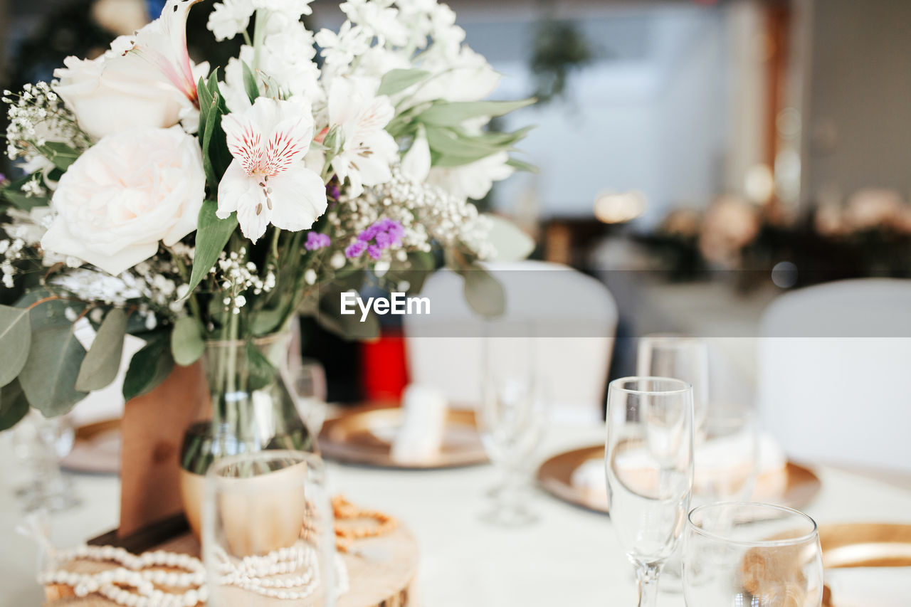 Modern wedding decor - guest tables with golden plates, eucalyptus leaves floral arrangements.