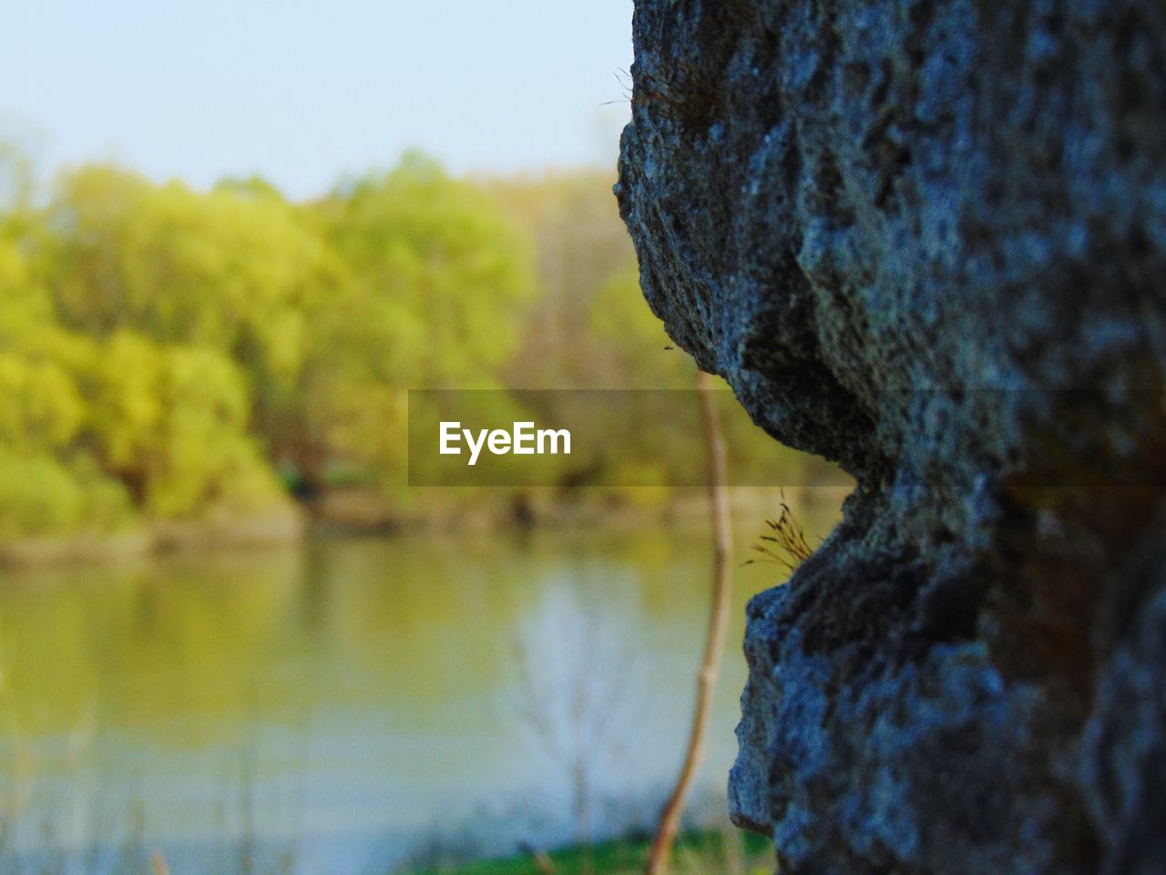 CLOSE-UP OF ROCK AGAINST LAKE