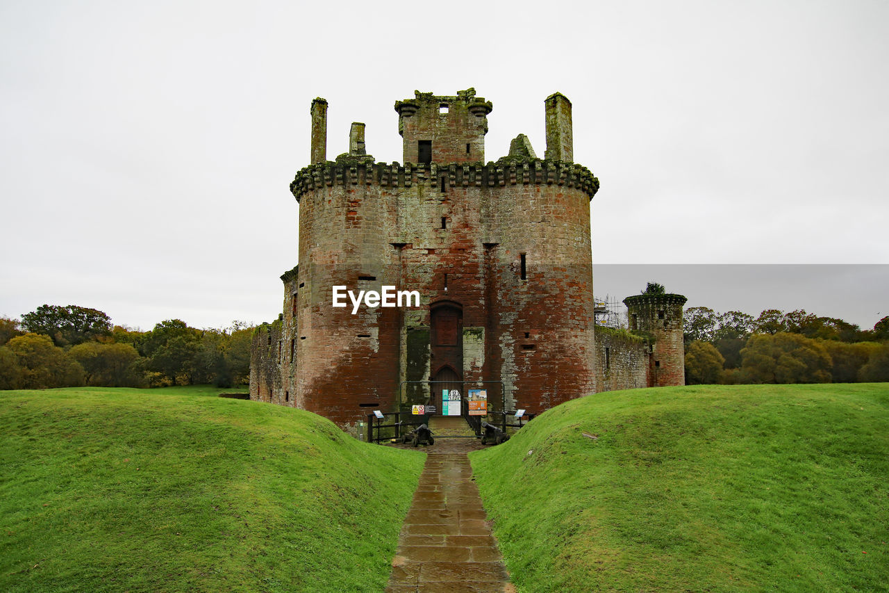 castle, architecture, history, the past, château, built structure, sky, building exterior, building, grass, fort, travel destinations, fortification, nature, travel, ancient, plant, old, old ruin, ruins, rural area, moat, tourism, medieval, cloud, no people, outdoors, wall, fortified wall, stately home, green, estate, landscape, abbey, land, tower, day, environment