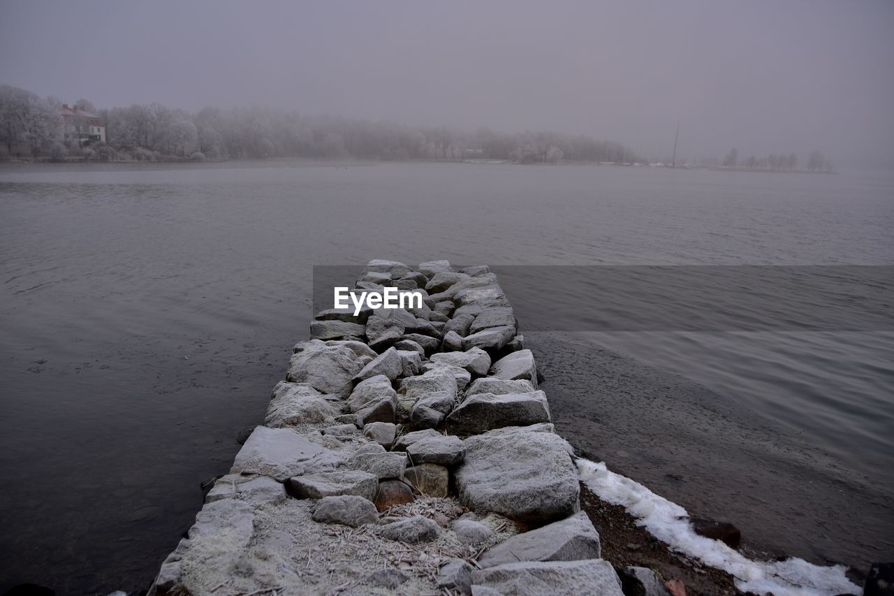 GROYNE IN LAKE AGAINST SKY