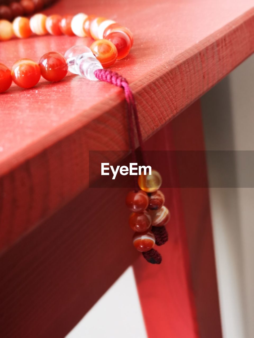 HIGH ANGLE VIEW OF MULTI COLORED DECORATION HANGING ON WOODEN