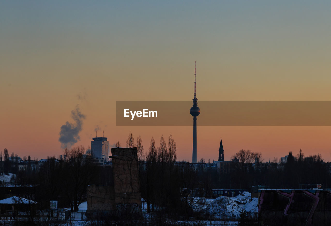 Fernsehturm tower against sky during sunset in city