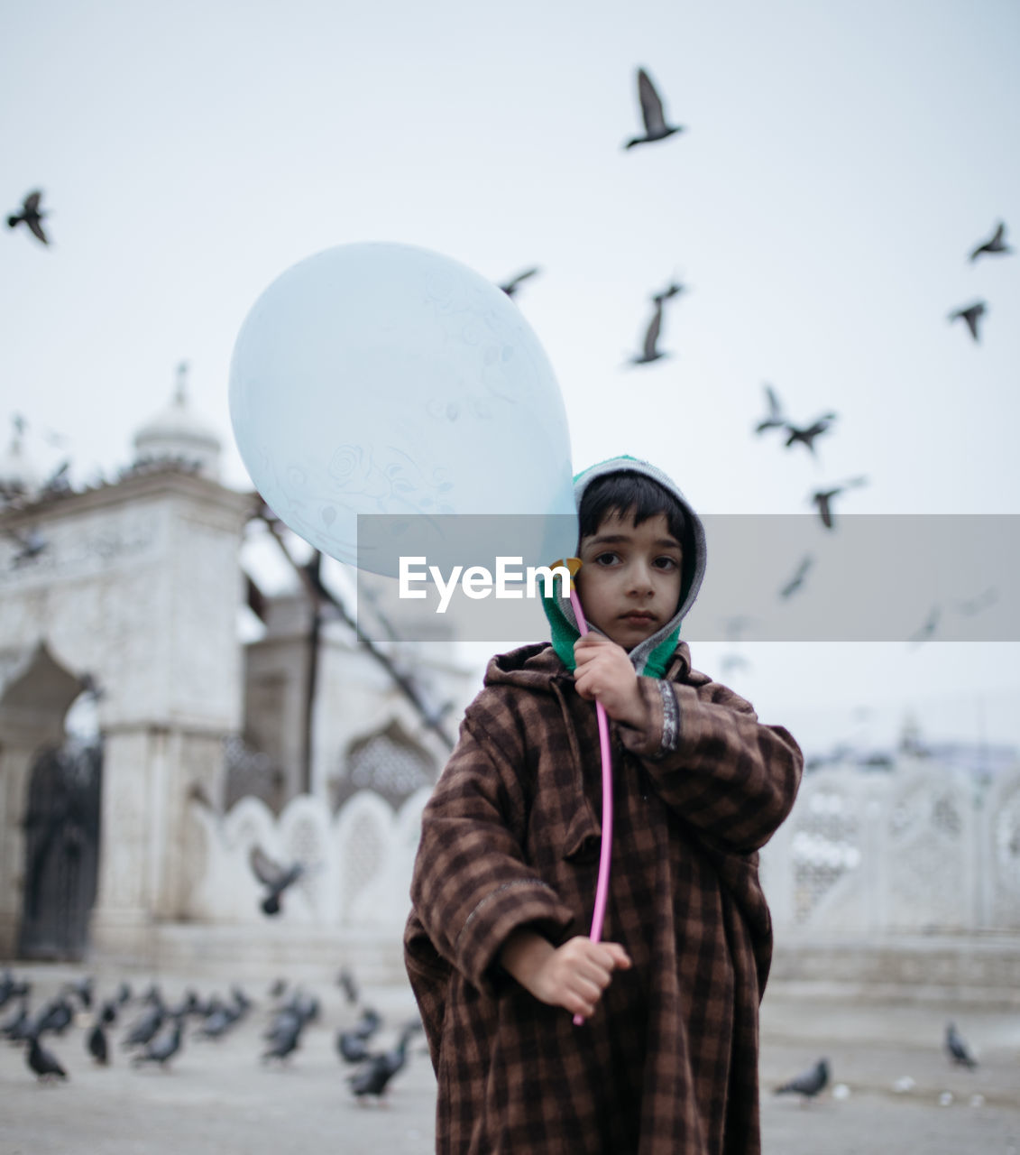 PORTRAIT OF BEAUTIFUL YOUNG WOMAN STANDING AGAINST SKY