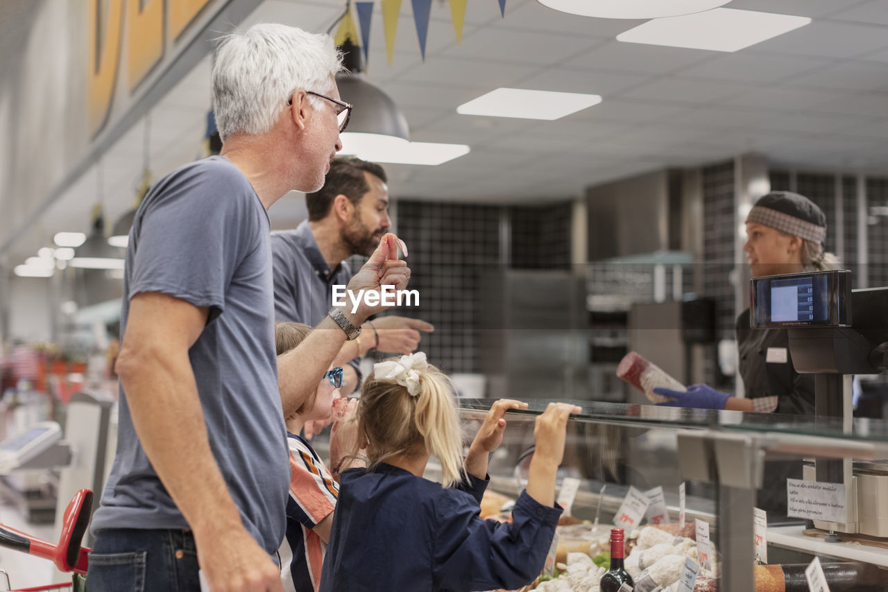Customers at deli counter in supermarket