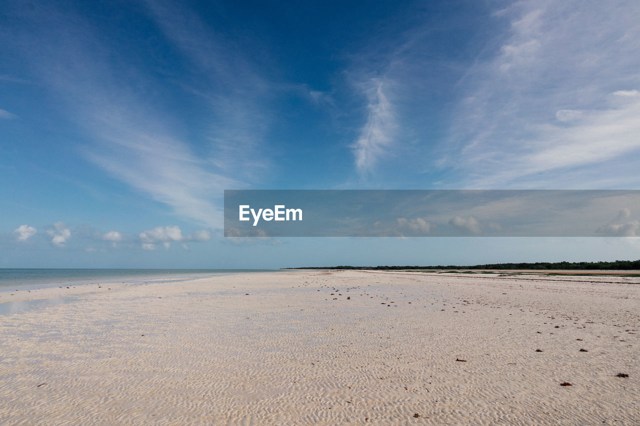 sky, land, horizon, sea, scenics - nature, water, cloud, sand, environment, landscape, beach, beauty in nature, nature, blue, shore, body of water, tranquility, ocean, coast, tranquil scene, travel destinations, natural environment, no people, travel, horizon over water, outdoors, day, tourism, seascape, summer, urban skyline, coastline, water's edge, non-urban scene, sunlight, wave, sunny, desert, animal wildlife, dramatic sky, cloudscape