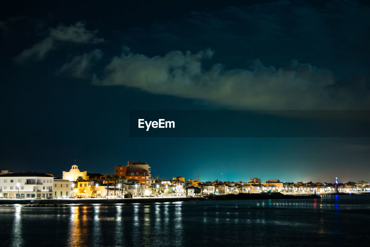 ILLUMINATED CITY AT WATERFRONT