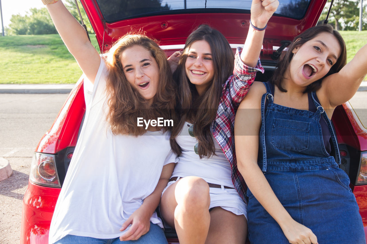 Portrait of happy female friends sitting in car