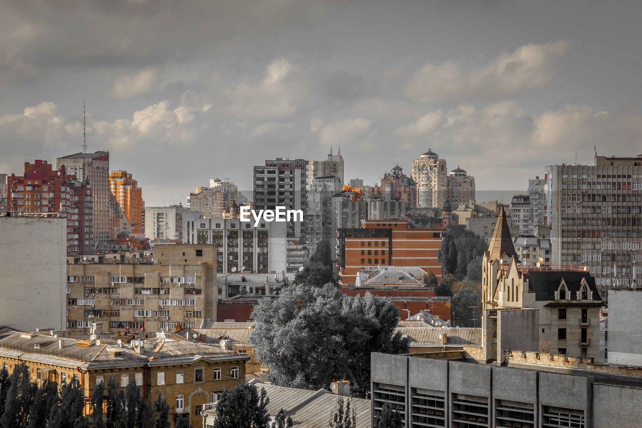 View of cityscape against cloudy sky