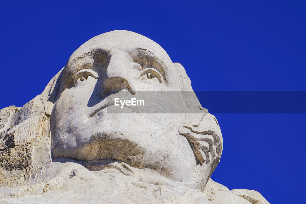 Low angle view of statue against clear blue sky