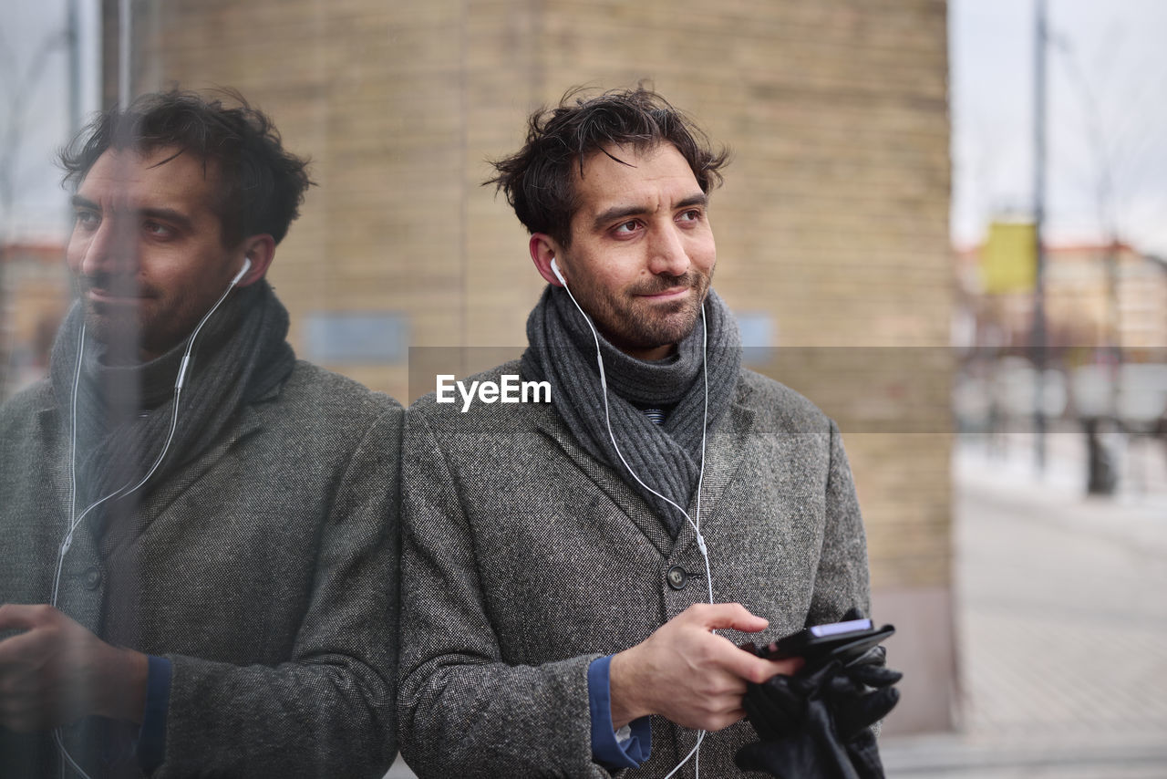 Elegant man with smartphone on street