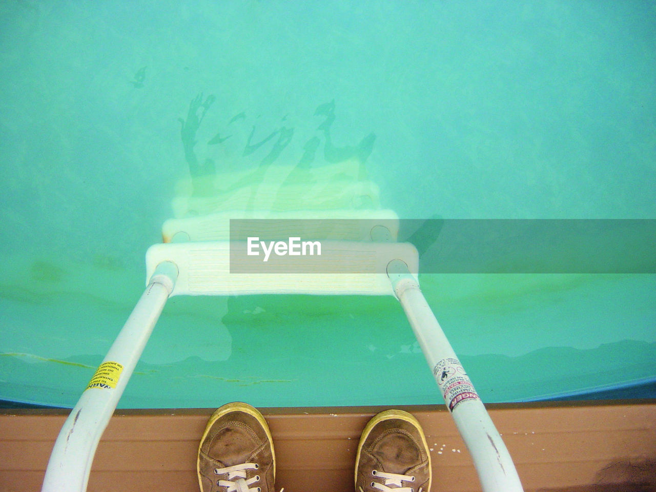 LOW SECTION OF MAN SWIMMING IN POOL