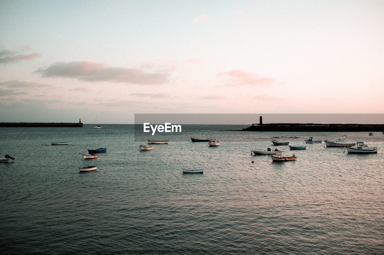 SAILBOATS ON SEA AGAINST SKY DURING SUNSET