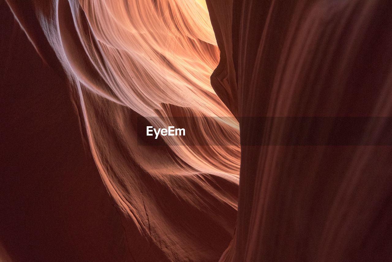 LOW ANGLE VIEW OF ROCK FORMATION IN DARK ROOM