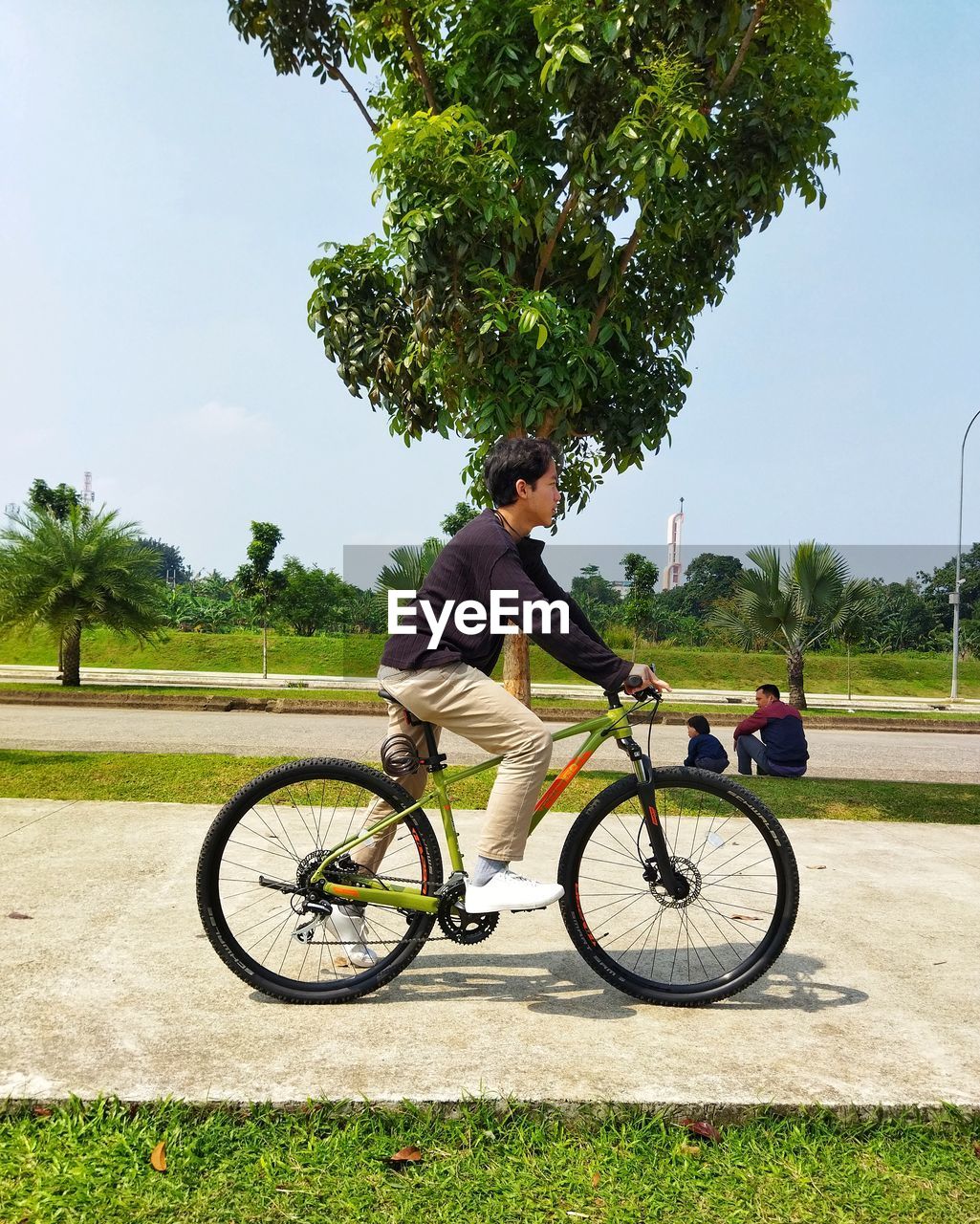 A teenager riding bicycle on bicycle lane.