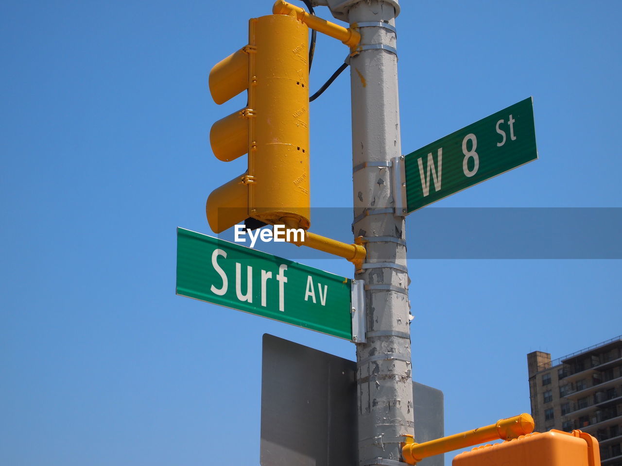 Low angle view of street name signs against clear blue sky