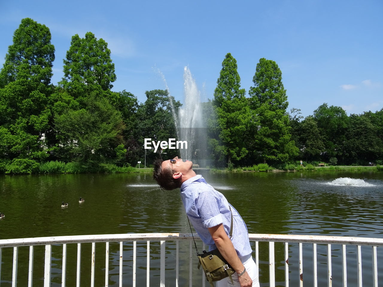 Side view of man standing against fountain