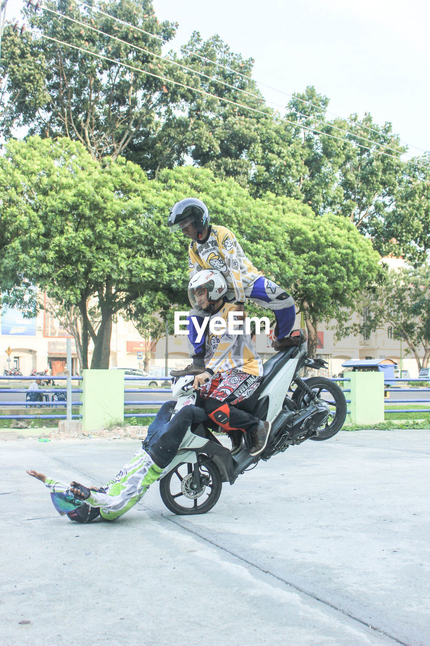 PEOPLE RIDING MOTORCYCLE ON ROAD