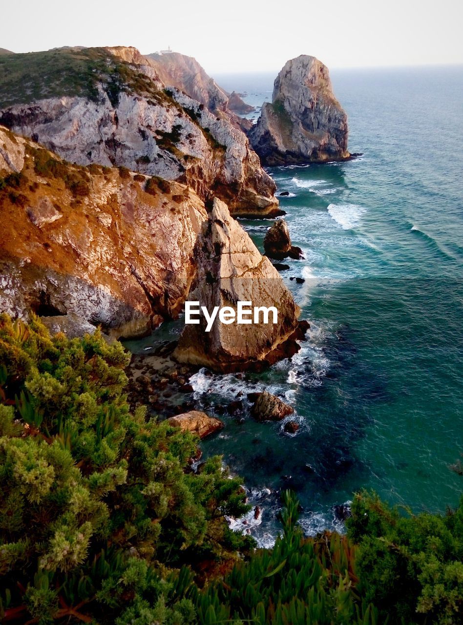 Rock formations by sea against sky