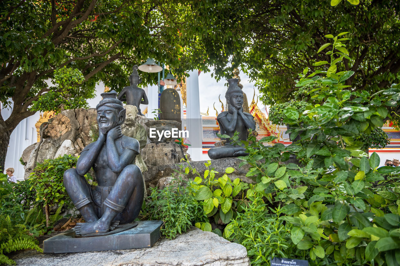 STATUE AGAINST TREES AND PLANTS