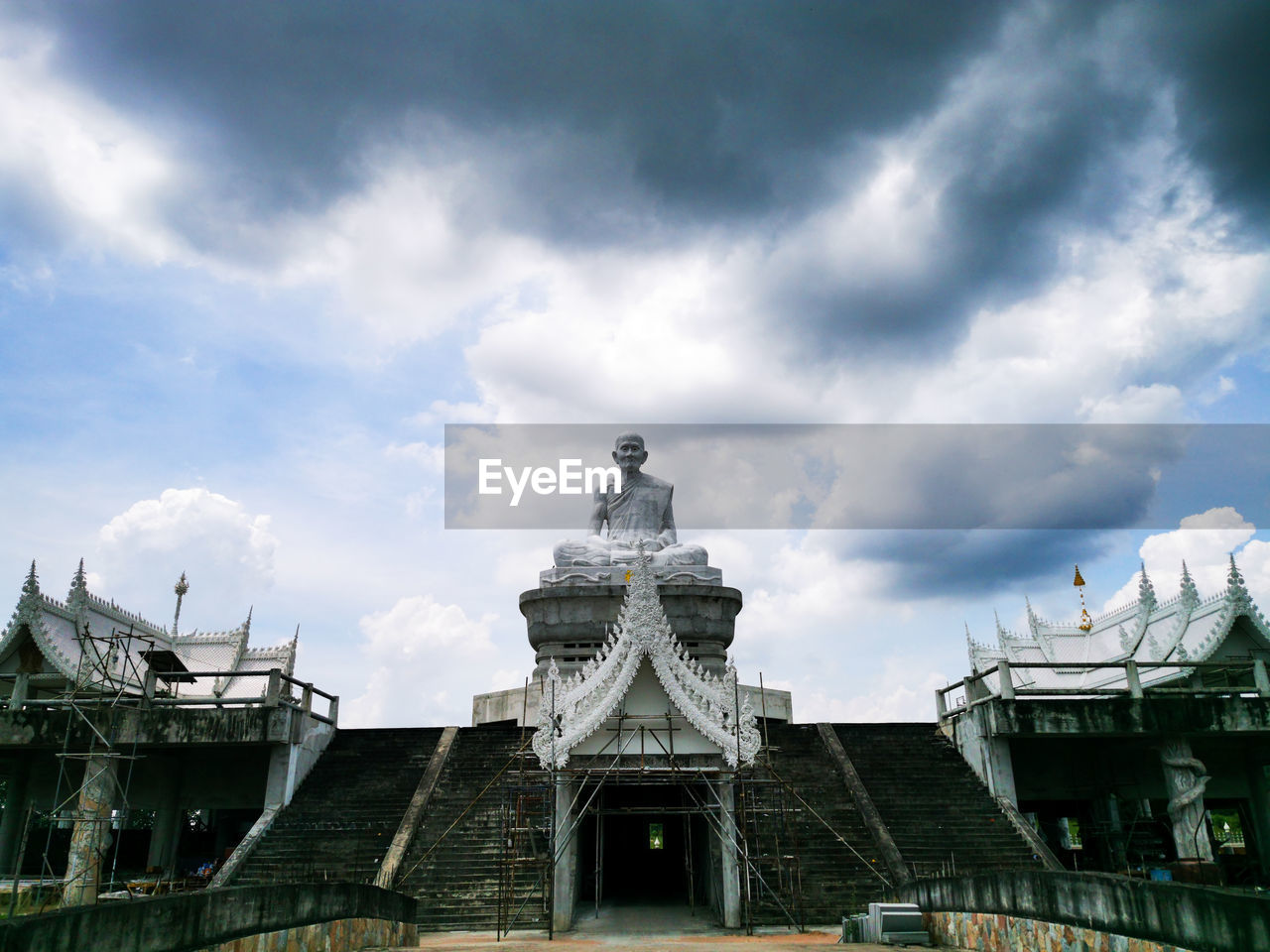 Low angle view of buddhist temple against cloudy sky