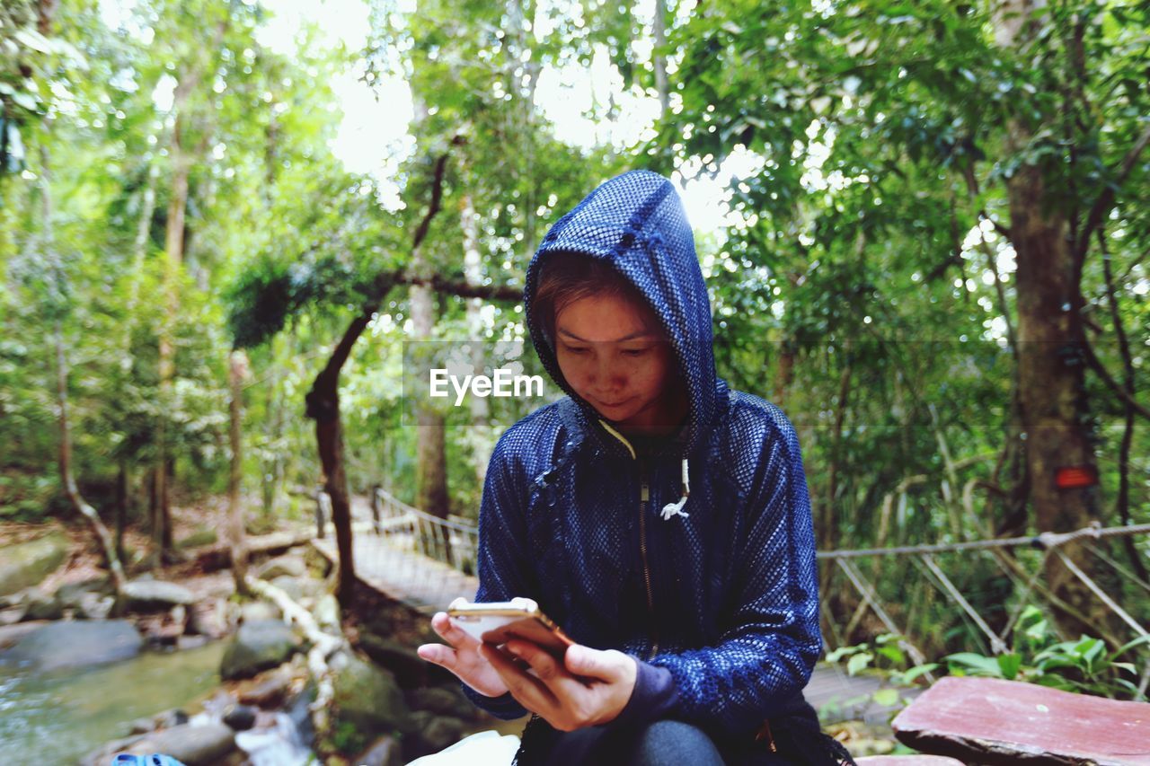 YOUNG MAN USING MOBILE PHONE IN PARK