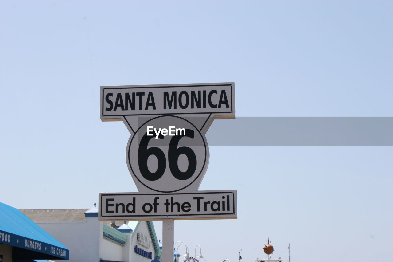 LOW ANGLE VIEW OF ROAD SIGNS AGAINST CLEAR BLUE SKY