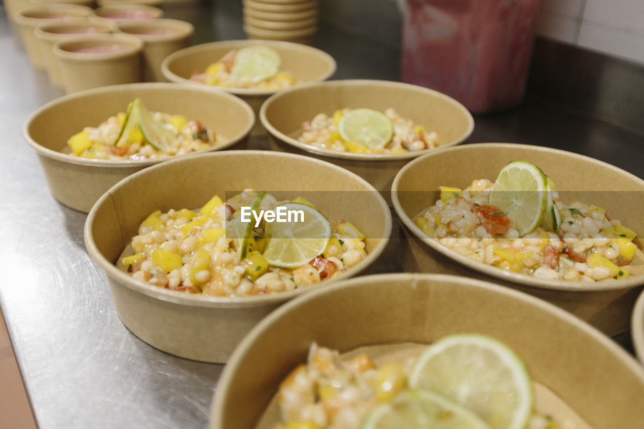 Vegetable salads prepared in a restaurant kitchen to take away. the containers used are compostable.